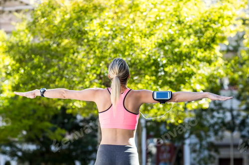 Preview: A beautiful athlete stretching her arms on a sunny day