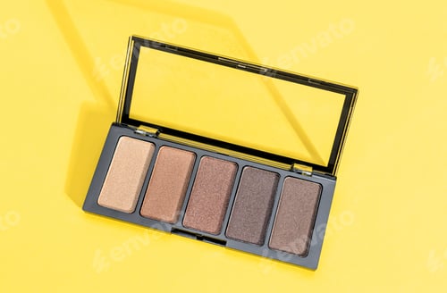 Preview: One palette of nude eyeshadows on yellow.
