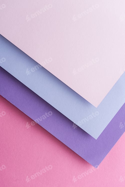 Preview: top view of blue, white and purple sheets of paper on pink background with copy space