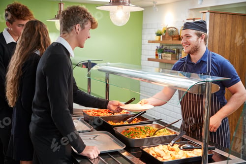 Preview: Teenage Students Being Served Meal In School Canteen