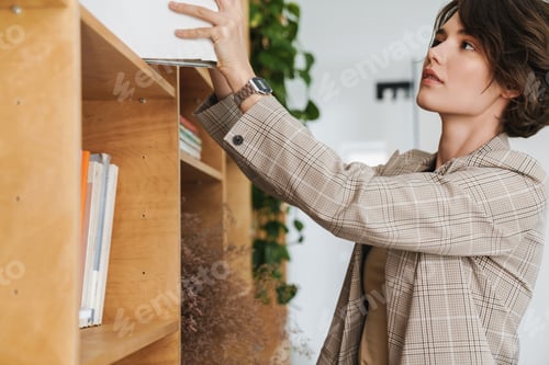 Preview: Attractive young woman entrepreneur taking book