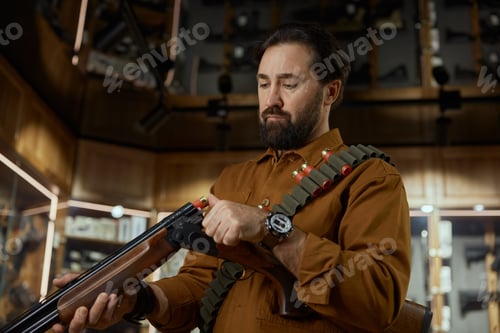 Preview: Man loading bullet into the rifle at legal commercial weapon store for hunting hobby