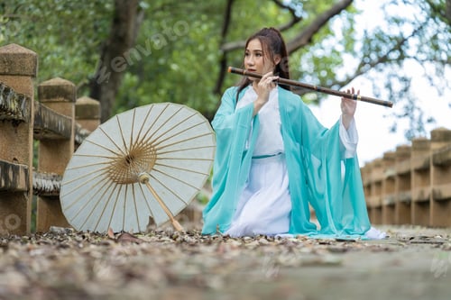Preview: Young beautiful Asian woman dressed in ancient Chinese warrior style with ancient fan