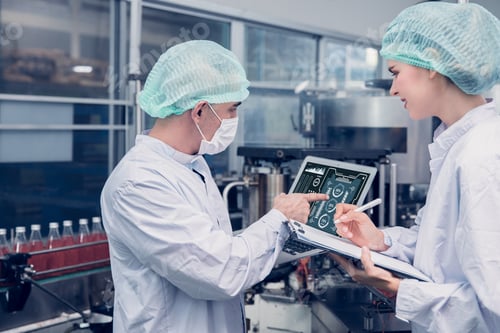 Preview: Food and Drink factory worker working together with hygiene monitor control ingredient machine