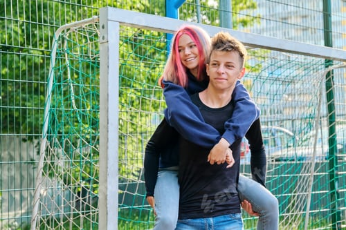 Preview: Couple of teenagers guy and girl having fun on an outdoor basketball court