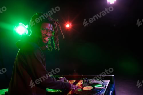 Vista previa: DJ profesional de club afroamericano con mezclador de sonido en discoteca