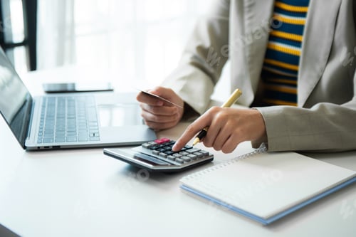 Preview: Businessman hands working with finances about cost and calculator and laptop with tablet,