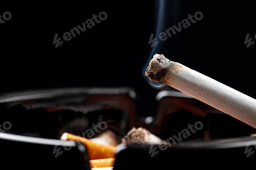 Preview: Burning cigarette in a black ash tray