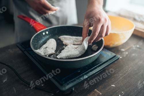 Preview: Chef cooking sea bass fish fillet on a frying pan