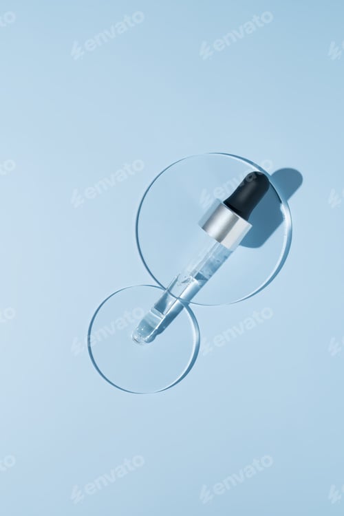 Preview: Pipette with sample of beauty serum cosmetic product in petri dish on blue background, hard shadows