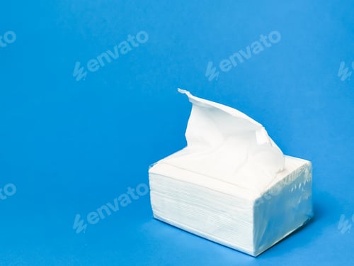 Preview: Photo a pack of white paper napkins against blue background.