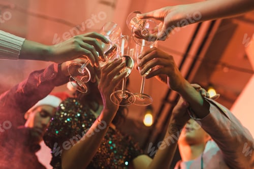 Visualização: visão parcial de amigos tilintando taças de champanhe durante a festa de ano novo