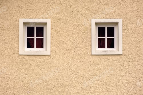 Preview: Two windows on a yellow facade wall of an old fashioned Europe house