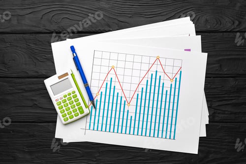 Preview: Business graphs paper and calculator on table