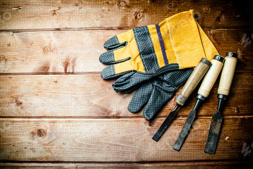 Preview: Chisel with construction gloves on the table.