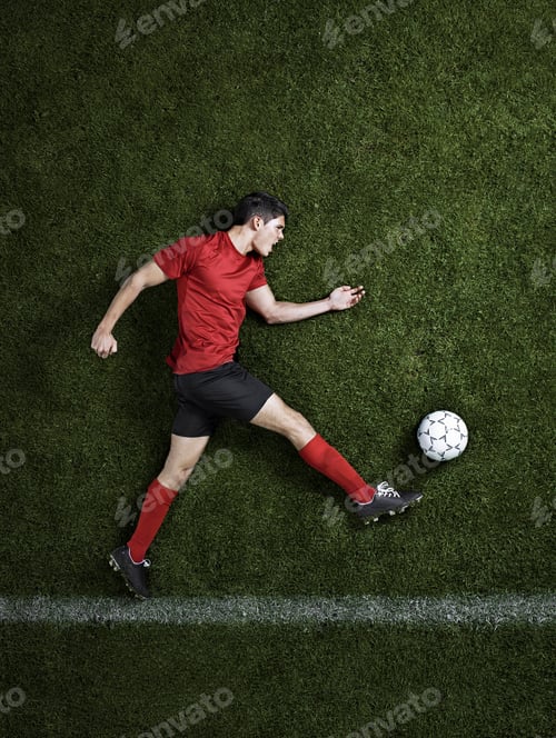 Preview: Soccer Player Kicking Ball on Green Field