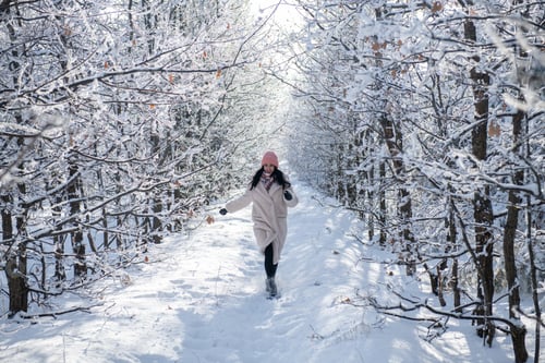 Preview: Woman Walking in Snowy Forest on Winter Day