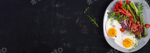 Preview: Keto breakfast. Fried asparagus with roasted eggs and prosciutto or jamon.