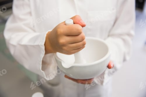 Preview: Junior pharmacist mixing a medicine at the hospital pharmacy