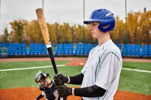 Preview: Teenage boys enjoy baseball on a youth sports field during an overcast afternoon