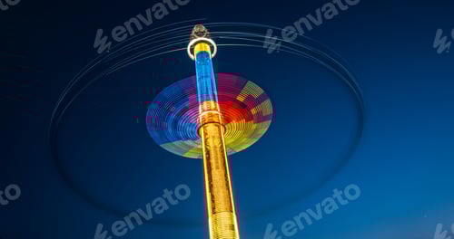 Vista previa: Rastros coloridos abstractos de carrusel frente al cielo oscuro