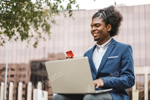 Preview: smiling afro businessman using shopping online with credit card