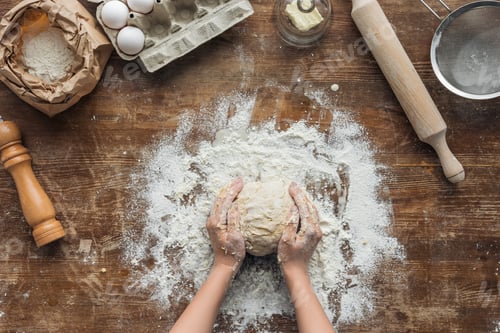 Preview: top view of female hands forming dough on wooden table