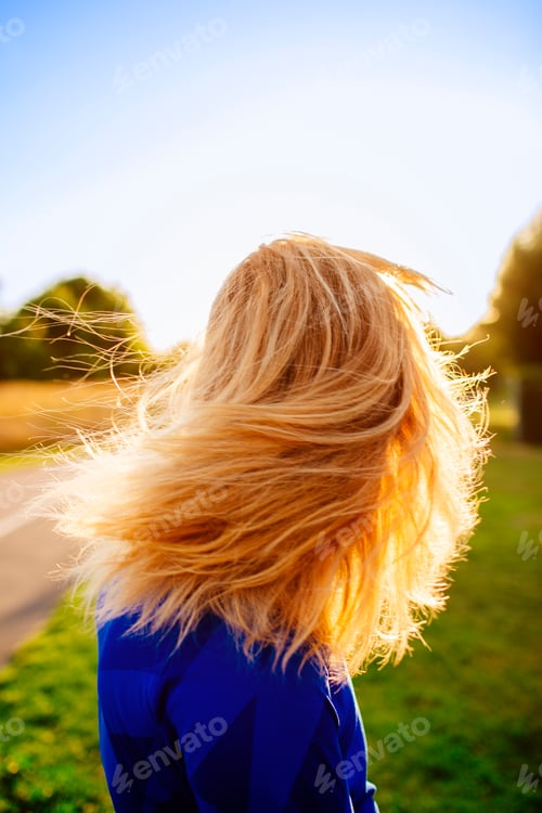 Preview: Side view of sporty woman tossing hair at park