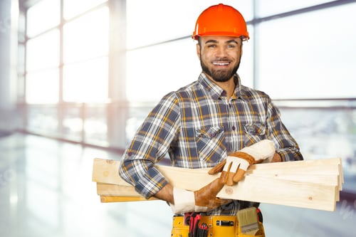 Preview: Skilled construction worker proudly carrying wooden planks in a modern building setting