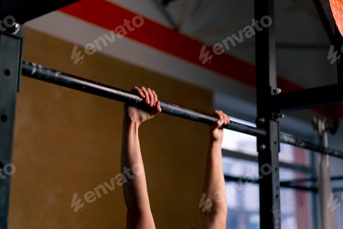 Preview: close up in the gym coach girl in black leggings and a top weighs on the horizontal bar