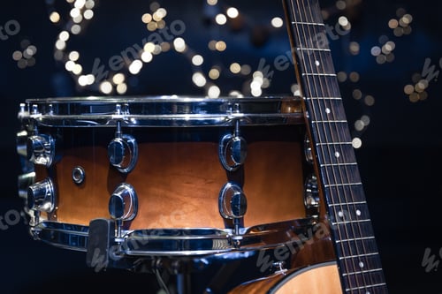 Preview: Snare drum and guitar on a blurry dark background with bokeh.