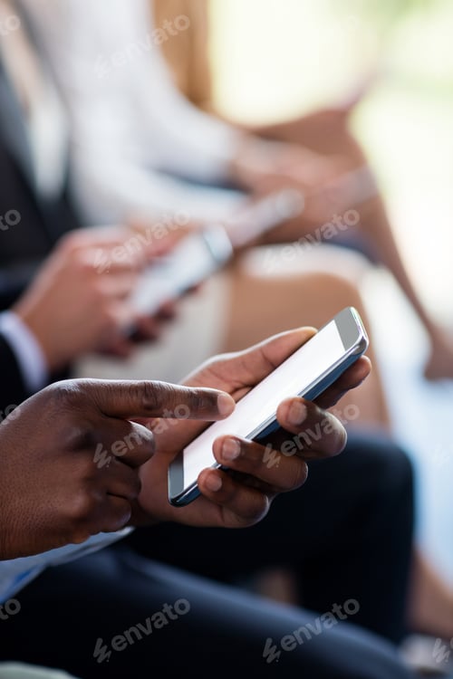 Preview: Close-up of business executives using mobile phone