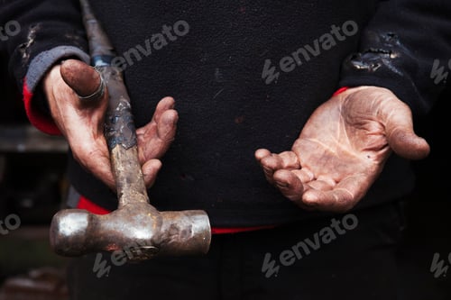 Preview: Close up of a blacksmith's hands, holding a metal hammer.