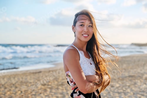 Preview: Outdoor portrait of young beautiful asian woman on beach, looking at camera
