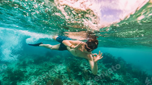 Preview: tourist doing the ok signal while he snorkel