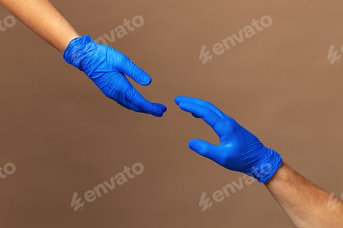 Preview: Male and female hands in medical gloves stretch to each other. Help concept.