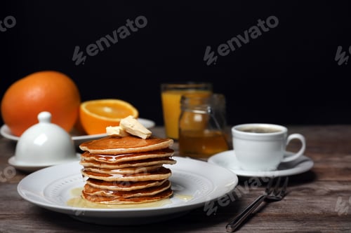 Preview: Delicious pancakes with butter and honey served for breakfast on table