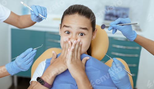 Preview: Shocked little girl with wide open eyes closed her mouth and does not give doctors to treat teeth