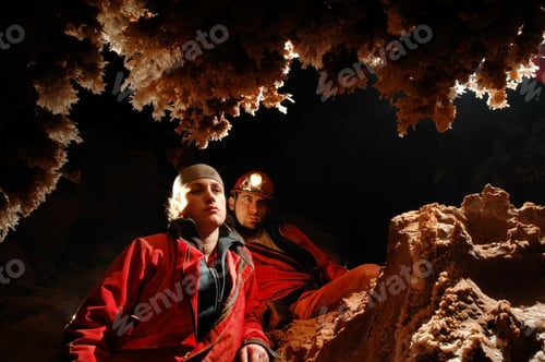 Preview: Spelunkers admiring stalactites in a cave