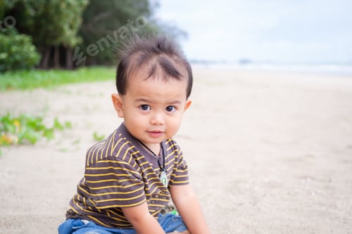 Preview: Cute child little boy 1 year old sitting on sand beach