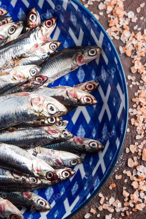 Preview: Blue fish. Anchovies in a dish with pink salt