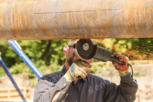 Preview: Worker cuts metal product with electric flex