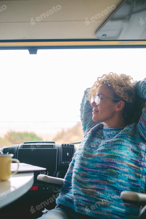 Preview: One serene woman having relax time indoor leisure activity sitting inside a camper van