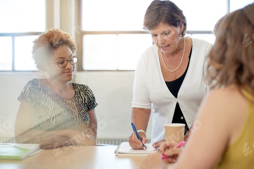 Visualização: Grupo indeterminado de empresários criativos em um escritório de conceito aberto discutindo ideias.