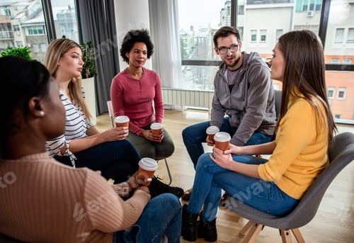 Preview: Diverse group of people sitting in circle in group therapy session.