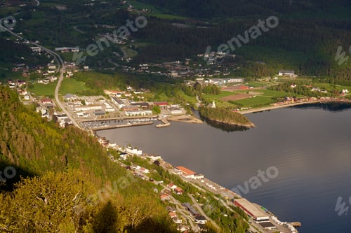 Preview: Aerial view of Sjoholt cityscape from a green hill near a lake in Norway