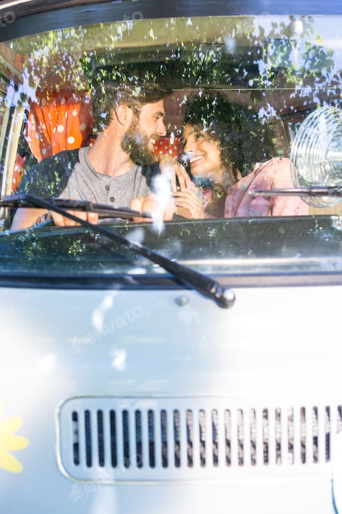 Preview: Hipster couple driving in camper van on a summers day