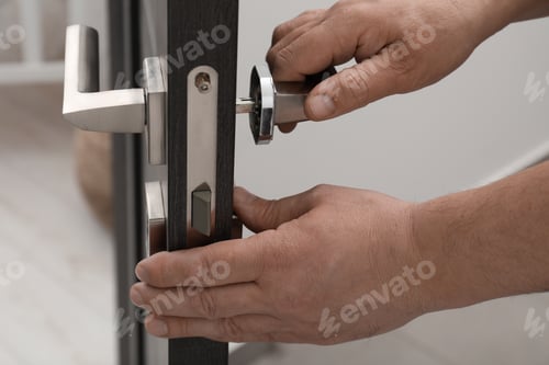 Preview: Handyman repairing door handle indoors, closeup view