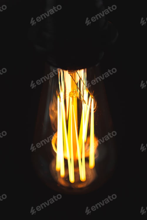 Preview: A classic Edison light bulb on dark background with space for text