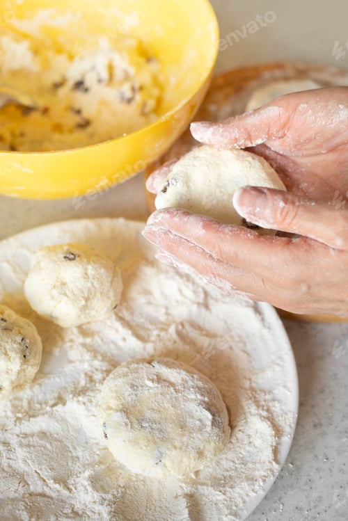 Preview: Caucasian hands making cottage cheese pancakes with raisins